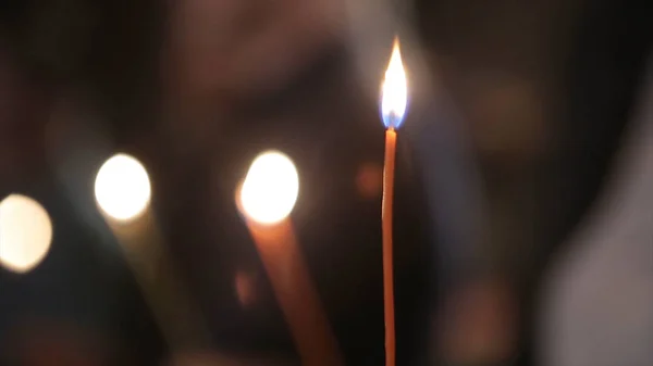 Tände ett ljus med en Match för att få en romantisk. Fantastiska ljusbehållare och ljusstakar är på bordet. Bo ljus med fridfull bakgrund av religiös ceremoni. — Stockfoto