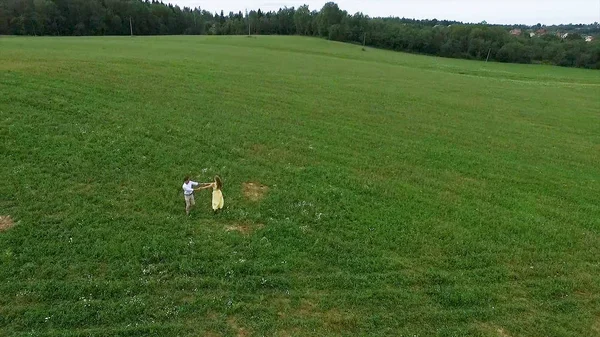Uçan nerede aşıklar yürümek yeşil alanın üzerinde. Kadın ve adam çalıştırdığı kenar boşluğu hava anketi. Alan. Sahada koşmak aşıkların hava anket