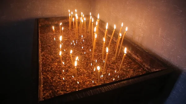 Tände ett ljus med en Match för att få en romantisk. Fantastiska ljusbehållare och ljusstakar är på bordet. Bo ljus med fridfull bakgrund av religiös ceremoni. — Stockfoto