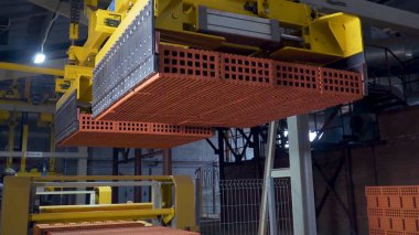 Tuğla üretimi için bitki. Yapı malzemesi ile hazır tuğla, inşaat sanayi üretimi için bitki. Üretim tesisi tuğla. İş akışı, yakın çekim. Birçok tuğla