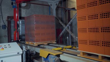 Tuğla üretimi için bitki. Yapı malzemesi ile hazır tuğla, inşaat sanayi üretimi için bitki. Üretim tesisi tuğla. İş akışı, yakın çekim. Birçok tuğla