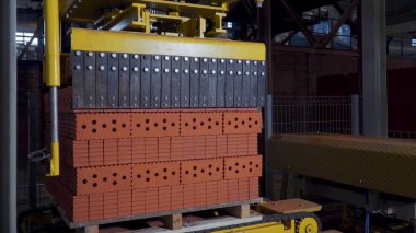 Tuğla üretimi için bitki. Yapı malzemesi ile hazır tuğla, inşaat sanayi üretimi için bitki. Üretim tesisi tuğla. İş akışı, yakın çekim. Birçok tuğla