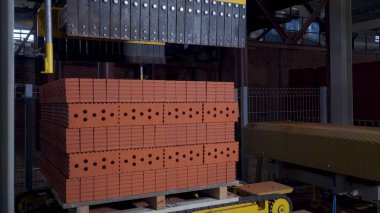 Tuğla üretimi için bitki. Yapı malzemesi ile hazır tuğla, inşaat sanayi üretimi için bitki. Üretim tesisi tuğla. İş akışı, yakın çekim. Birçok tuğla