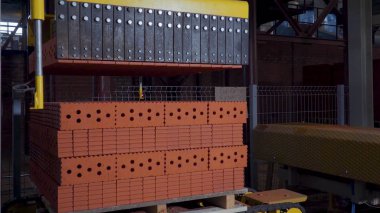 Tuğla üretimi için bitki. Yapı malzemesi ile hazır tuğla, inşaat sanayi üretimi için bitki. Üretim tesisi tuğla. İş akışı, yakın çekim. Birçok tuğla