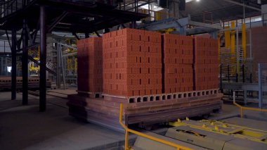 Tuğla üretimi için bitki. Yapı malzemesi ile hazır tuğla, inşaat sanayi üretimi için bitki. Üretim tesisi tuğla. İş akışı, yakın çekim. Tuğla yığınları. Birçok tuğla