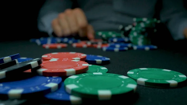 Werfen Sie die blauen Chips im Poker. blau und rot spielen Pokerchips in reflektierendem schwarzen Hintergrund. Nahaufnahme von Pokerchips in Stapeln auf der grünen Filztischoberfläche in Zeitlupe — Stockfoto