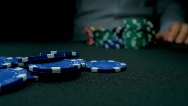 Werfen Sie die blauen Chips im Poker. blau und rot spielen Pokerchips in reflektierendem schwarzen Hintergrund. Nahaufnahme von Pokerchips in Stapeln auf der grünen Filztischoberfläche in Zeitlupe — Stockfoto