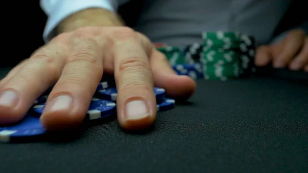 Werfen Sie die blauen Chips im Poker. blau und rot spielen Pokerchips in reflektierendem schwarzen Hintergrund. Nahaufnahme von Pokerchips in Stapeln auf der grünen Filztischoberfläche in Zeitlupe — Stockfoto