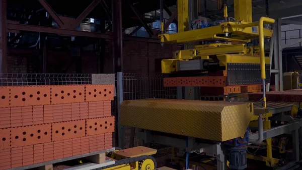 Tuğla üretimi için bitki. Yapı malzemesi ile hazır tuğla, inşaat sanayi üretimi için bitki. Üretim tesisi tuğla. İş akışı, yakın çekim. Birçok tuğla