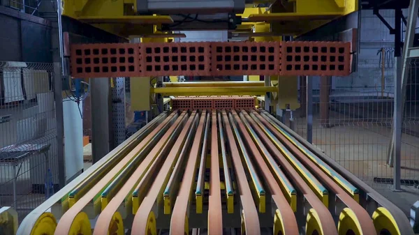 Tuğla üretimi için bitki. Yapı malzemesi ile hazır tuğla, inşaat sanayi üretimi için bitki. Üretim tesisi tuğla. İş akışı, yakın çekim. Birçok tuğla