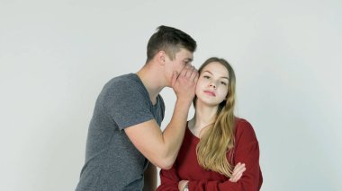 Güzel kız gizli beyaz arka plan - dostluk kavramı üzerine gülen onun arkadaşı kulağına fısıldayan