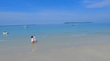 Okyanusa - çalışan erkek ve kız arkadaşı gidiş gün batımında denizde yüzmeyi sevenler birkaç. İki aşık. Plaj doğru sığ su ile çalışan genç bir çift. Su sıçramasına.