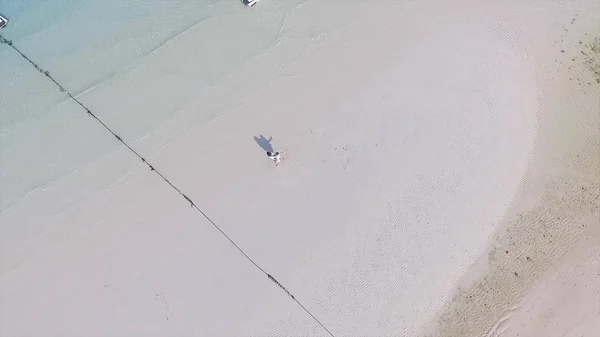 Lyckliga paret tillsammans på stranden. Ungt par njuter av varandra på en strand. En ung man och kvinna har kul Dans som romantiska par på en strand med klarblå himmel och hav. — Stockfoto