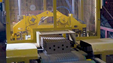 Tuğla üretimi için bitki. Yapı malzemesi ile hazır tuğla, inşaat sanayi üretimi için bitki. Üretim tesisi tuğla. İş akışı, yakın çekim. Birçok tuğla