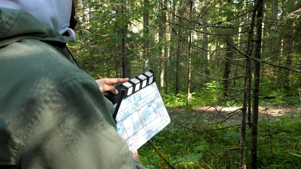 Movie clapper in forest. Clapperboard in forest. Film shooting in forest areas