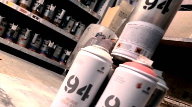 Sprey boya lekeleri ile kirli gri arka plan üzerine boyar. Sprey boya lekeleri ile kirli gri arka plan üzerine boyar. Spry şişeler, sokak sanatı. Sprey boya, altın rengi, yakın çekim.