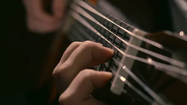 Practicing in playing guitar. Handsome young men playing guitar. Play the guitar. Hands playing guitar in diagonal position