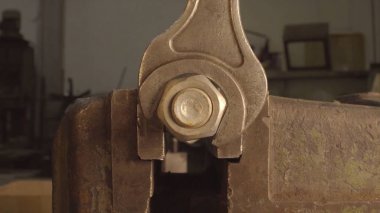 Demir anahtarı elinde büyük onaltılık cıvata unscrews. İngiliz anahtarı raf katlama mavi metal krom somun sıkma. Demir anahtarı elinde büyük onaltılık cıvata unscrews. İngiliz anahtarı çelik araçları onarım için