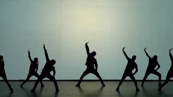 Dans van de schaduwen. De dansers dansen op het podium. Dansers silhouetten. Dans de schaduwen. 3D dansshow — Stockfoto