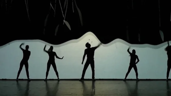 Dans van de schaduwen. De dansers dansen op het podium. Dansers silhouetten. Dans de schaduwen. 3D dansshow — Stockfoto