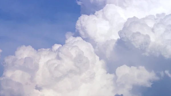 Blue sky with clouds timelapse. White big cloud on blue sky. a big and fluffy cumulonimbus cloud in the blue sky. Edge of a large white cloud timelapse. panorama. landscape blue sky moving timelapse