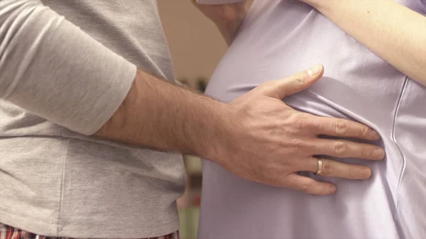 Τα χέρια του συζύγου για την κοιλιά των εγκύων τη σύζυγό. σύζυγος χάιδεψε τρυφερά την έγκυο κοιλιά της συζύγου του. Νεαρός άνδρας εγκεφαλικά επεισόδια έγκυος κοιλιά του όμορφη γυναίκα. Σύζυγος φιλί έγκυο κοιλιά — Φωτογραφία Αρχείου