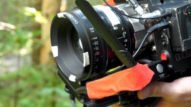 Ormanın içinde bir film filme bir kamera tutan adam. Ormanda film için pahalı kamera