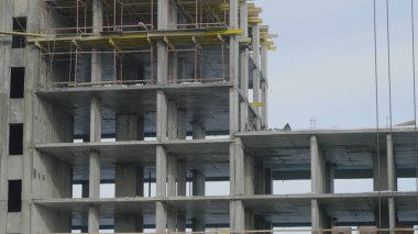 Yapı İnşaat site işi mavi gökyüzü karşı. Bir apartman, inşaat sahasında işçiler