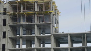 Yapı İnşaat site işi mavi gökyüzü karşı. Bir apartman, inşaat sahasında işçiler