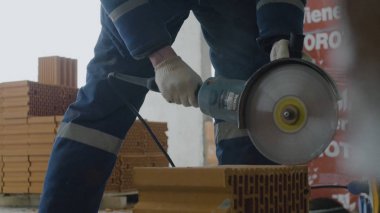 İşçi kesim tuğla. Daire testere veya değirmeni ile tuğla kesme