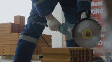 İşçi kesim tuğla. Daire testere veya değirmeni ile tuğla kesme