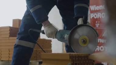 İşçi kesim tuğla. Daire testere veya değirmeni ile tuğla kesme