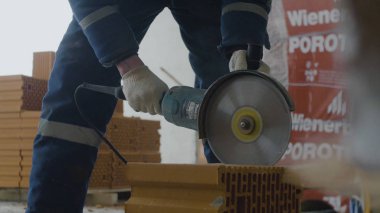 İşçi kesim tuğla. Daire testere veya değirmeni ile tuğla kesme