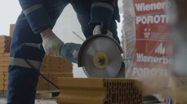 İşçi kesim tuğla. Daire testere veya değirmeni ile tuğla kesme