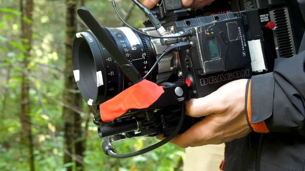 Man holding a camera filming a movie in the forest. Expensive camera for movie in the woods — Stock Photo, Image