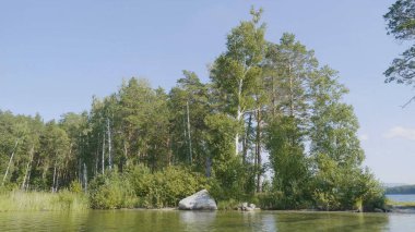Göl kıyısında güzel mavi temiz su. Orman manzara suda yansıtılmış sahilinde