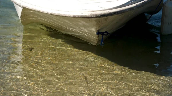 Boot in de buurt van de kust, kristal helder water. Boot zwemt tot de oever van het meer, dus de mensen ging aan wal — Stockfoto