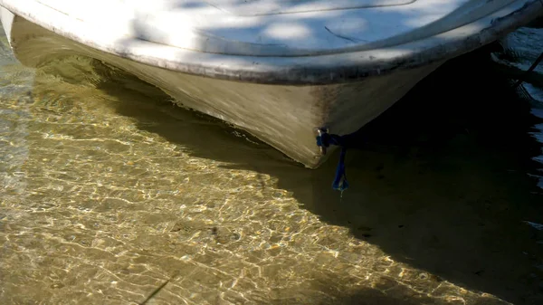Лодка возле берега, кристально чистая вода. Лодка плывет к берегу озера, так что люди сошли на берег — стоковое фото