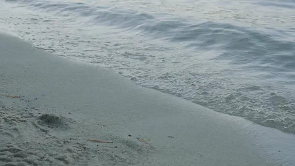 Sanfte Welle des Meeres am Sandstrand. Nahaufnahme Detail der schäumenden Meereswellen, die am Strand anspülen — Stockfoto