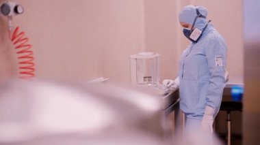 Laboratuvar şişelerde örnek çalımakta koruyucu kıyafetli kadın bilim adamı. Bilim adamı bir kimyasal laboratuvar