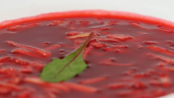 Cibo nazionale ucraino e russo - zuppa di barbabietola rossa borscht con manzo. Chiudete. piatto di zuppa di crema di barbabietole su strofinaccio a scacchi. Cibo nazionale russo, zuppa di barbabietole rosse, borscht — Foto Stock