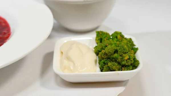 Roter Borschtsch mit Fleisch im Teller. ein köstlicher roter Borschtsch mit saurer Sahne und Kräutern auf einem weißen Teller. traditionelle ukrainische Rote-Bete-Suppe - roter Borschtsch und Knödel mit Knoblauch — Stockfoto