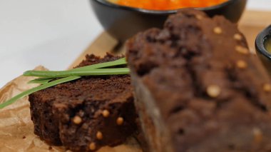 Doğranmış tereyağı, havyar, siyah ekmek. Kaşık ile kırmızı havyar kase dilimlenmiş ekmek, tereyağı ve otlar beyaz arka plan üzerinde hizmet verdi. Kepekli ekmek, tereyağı ve kırmızı havyar, beyaz arka plan