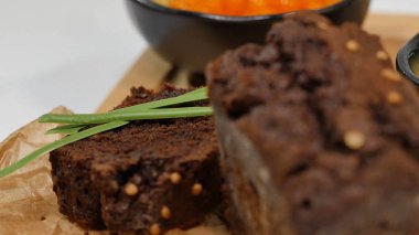 Doğranmış tereyağı, havyar, siyah ekmek. Kaşık ile kırmızı havyar kase dilimlenmiş ekmek, tereyağı ve otlar beyaz arka plan üzerinde hizmet verdi. Kepekli ekmek, tereyağı ve kırmızı havyar, beyaz arka plan