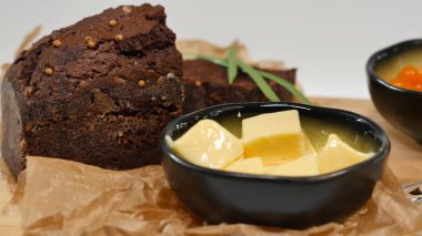 Doğranmış tereyağı, havyar, siyah ekmek. Kaşık ile kırmızı havyar kase dilimlenmiş ekmek, tereyağı ve otlar beyaz arka plan üzerinde hizmet verdi. Kepekli ekmek, tereyağı ve kırmızı havyar, beyaz arka plan