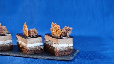 Koyu mavi zemin üzerine masada tabakta lezzetli çikolatalı kek. Tatlı - çikolatalı kek