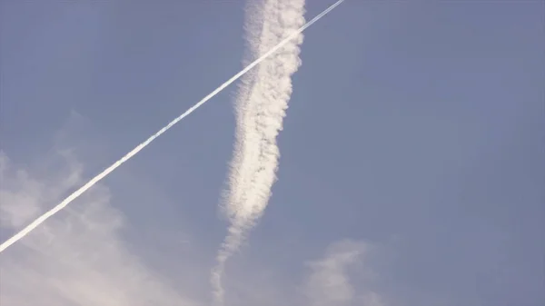 Grand avion supersonique de passagers volant haut dans un ciel bleu clair, laissant une longue traînée blanche. Avions laissant des traces en diagonale sur un ciel bleu clair. Une longue traînée d'avion à réaction sur ciel bleu — Photo