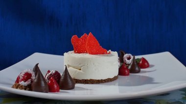 Kek beze krema ve ahududu. Taze Ahududu ve koyu mavi zemin üzerine yaban mersini ile Meringues Pavlova kek. Büyük beze zephyr plaka üzerinde