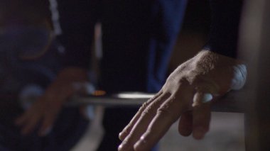 Grip - barbell bench press. Adam kulpları bar barbell bench press için. Makro. Yandan odaklan. Bench press halter portre yapan adam