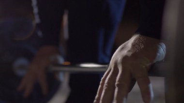 Grip - barbell bench press. Adam kulpları bar barbell bench press için. Makro. Yandan odaklan. Bench press halter portre yapan adam